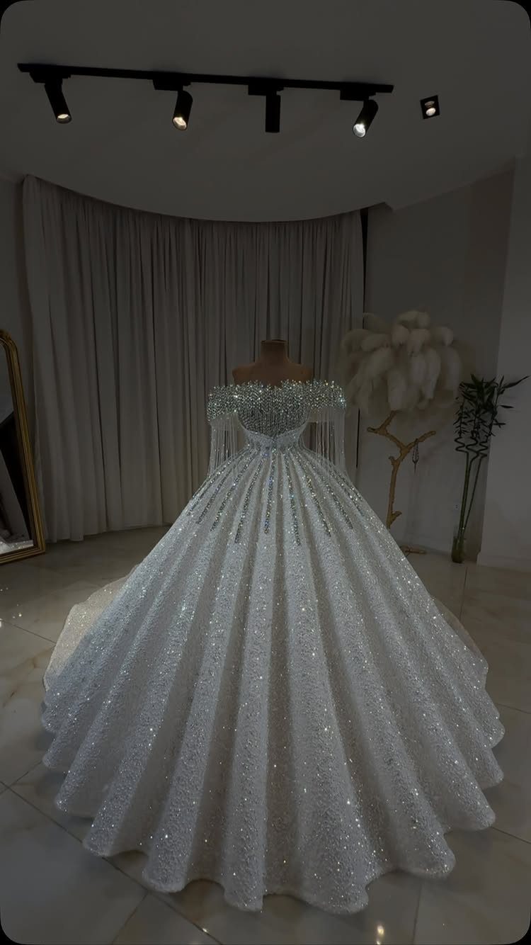 White sparkling ball gown wedding dress with voluminous skirt on a mannequin.