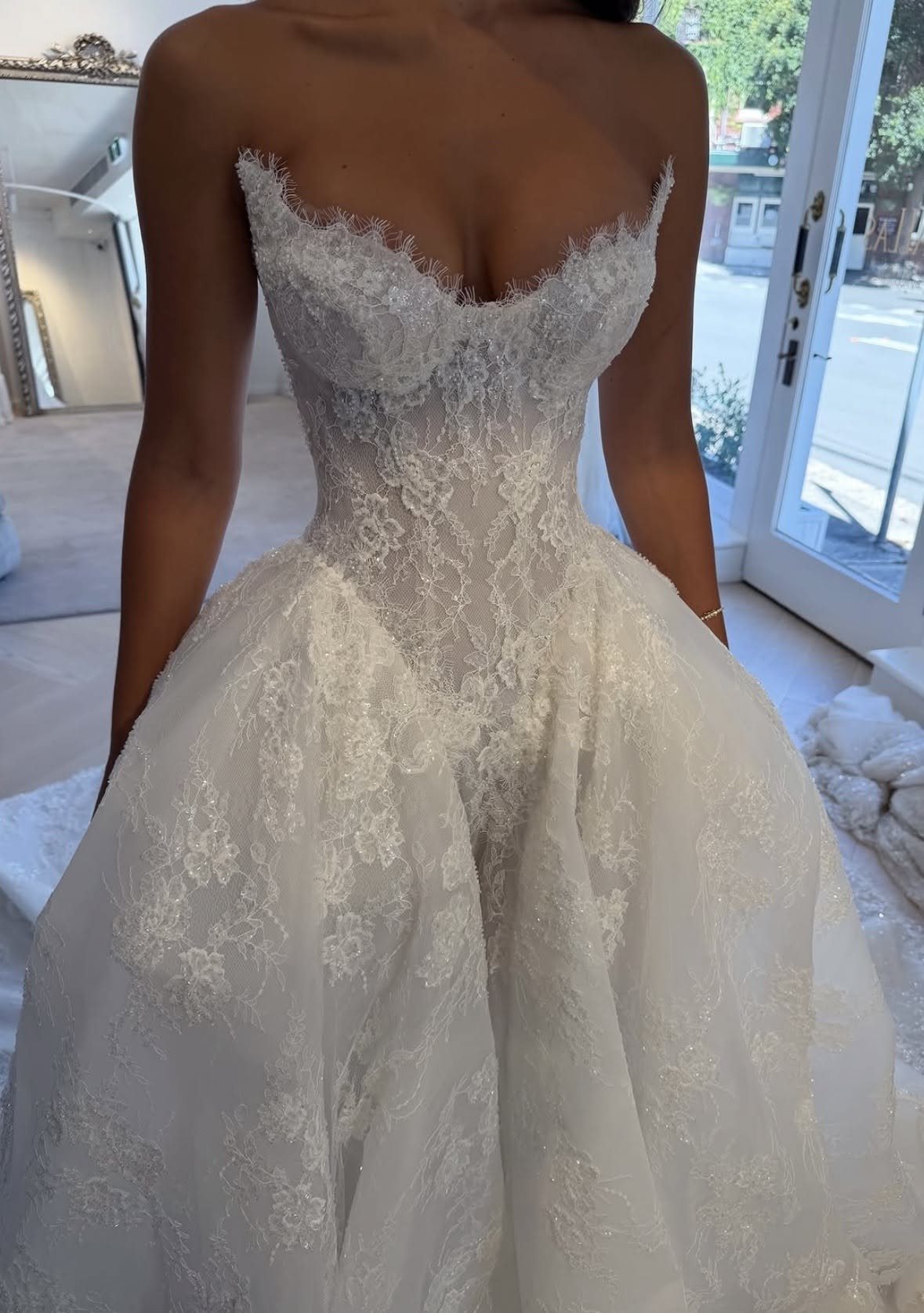 Basque Waist Wedding Dress Lace Ideas: 5 Styles 2 White lace wedding dress with a voluminous flaring A-line skirt and structured bodice.