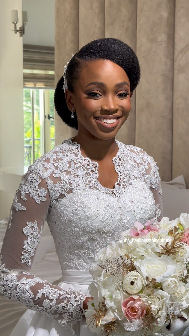 11 Black Natural Hair Wedding Hairstyles for Brides 6 Bride with a sleek updo and sparkling silver hair accessory holding a bouquet.