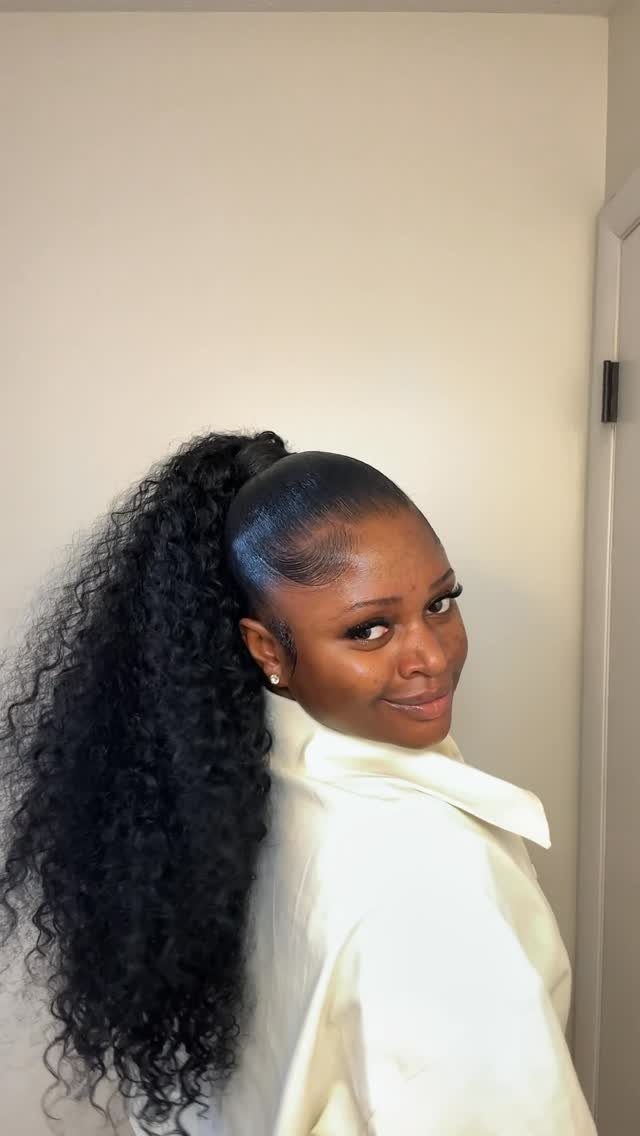 11 Black Natural Hair Wedding Hairstyles for Brides 9 Woman with long curly black natural hair in a high ponytail wearing white robe.