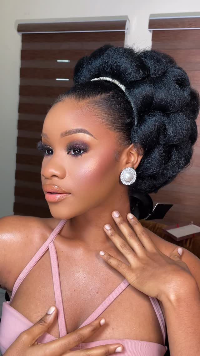 11 Black Natural Hair Wedding Hairstyles for Brides 11 Woman with a voluminous natural hair updo, sparkling headband, and pearl earrings.