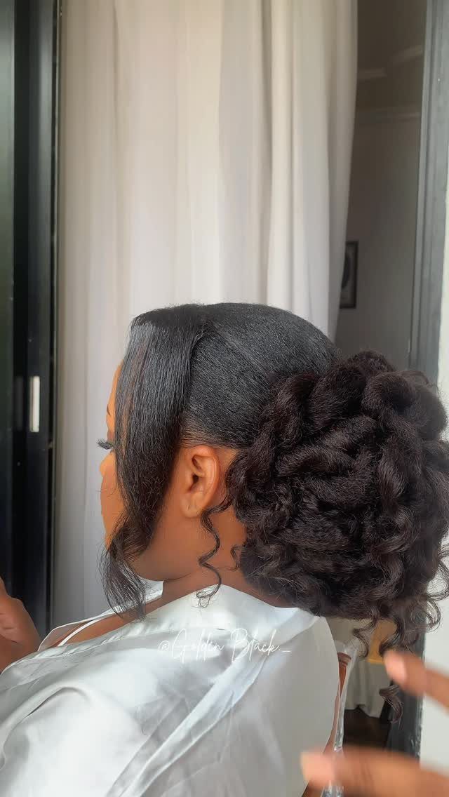 11 Black Natural Hair Wedding Hairstyles for Brides 4 Woman with a voluminous wavy chignon hairstyle wearing a white satin robe.