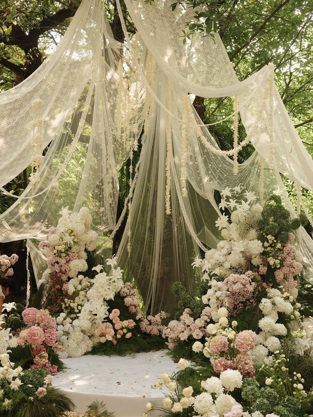 Bohemian Chic Wedding Ideas: 5 Looks and Details 5 Wedding altar with draped white lace fabrics and pink and white floral arrangements.