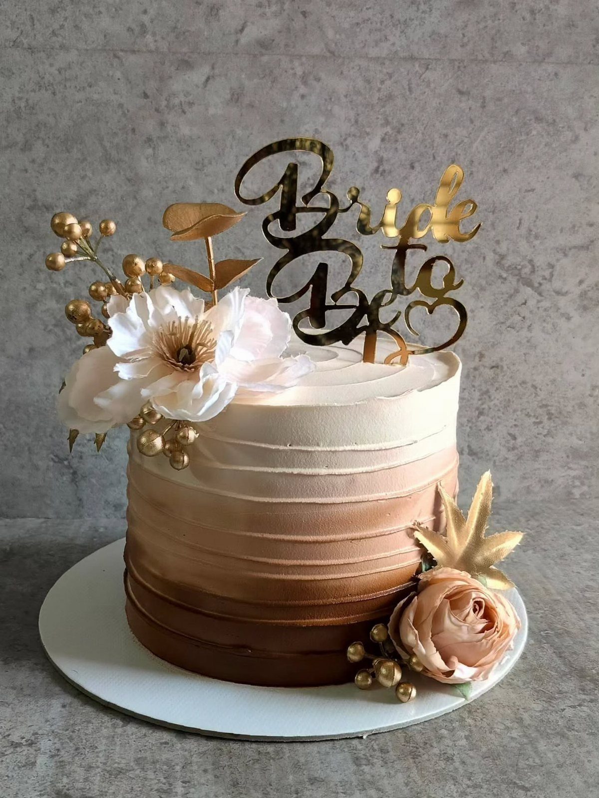 Ombre buttercream cake with gold Bride To Be topper and floral decorations