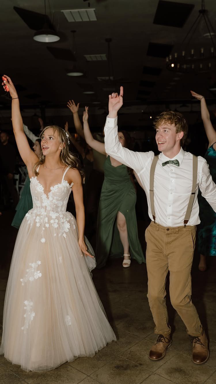 Bride and groom dancing at a casual wedding reception with guests in background