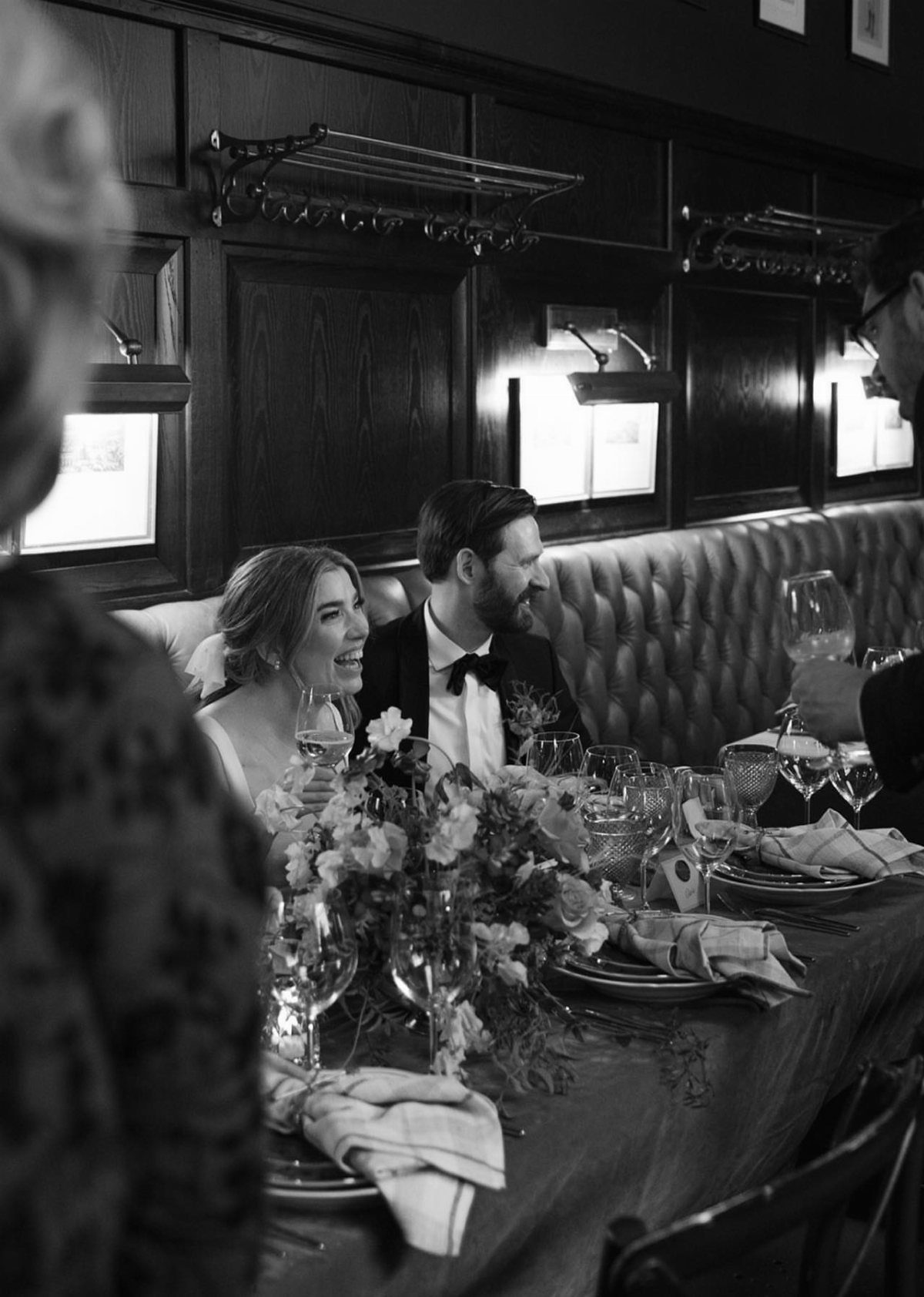 City Hall Wedding Ideas: 7 Ways to Plan the Day 2 Bride and groom smiling at a decorated dinner table in a restaurant booth.