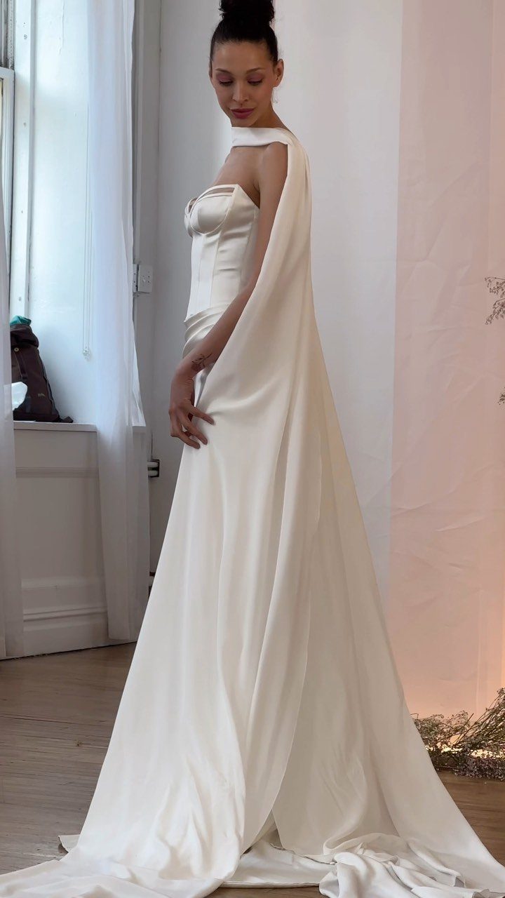 Corset Style Wedding Dress Ideas: 8 Designs to Love 1 Woman in a white satin wedding dress with a structured corset bodice and flowing skirt.