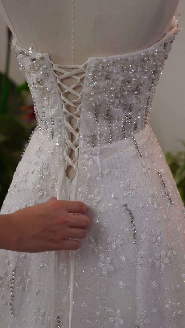 Corset Style Wedding Dress Ideas: 8 Designs to Love 7 White wedding dress on mannequin with a lace-up corset back and silver beading.