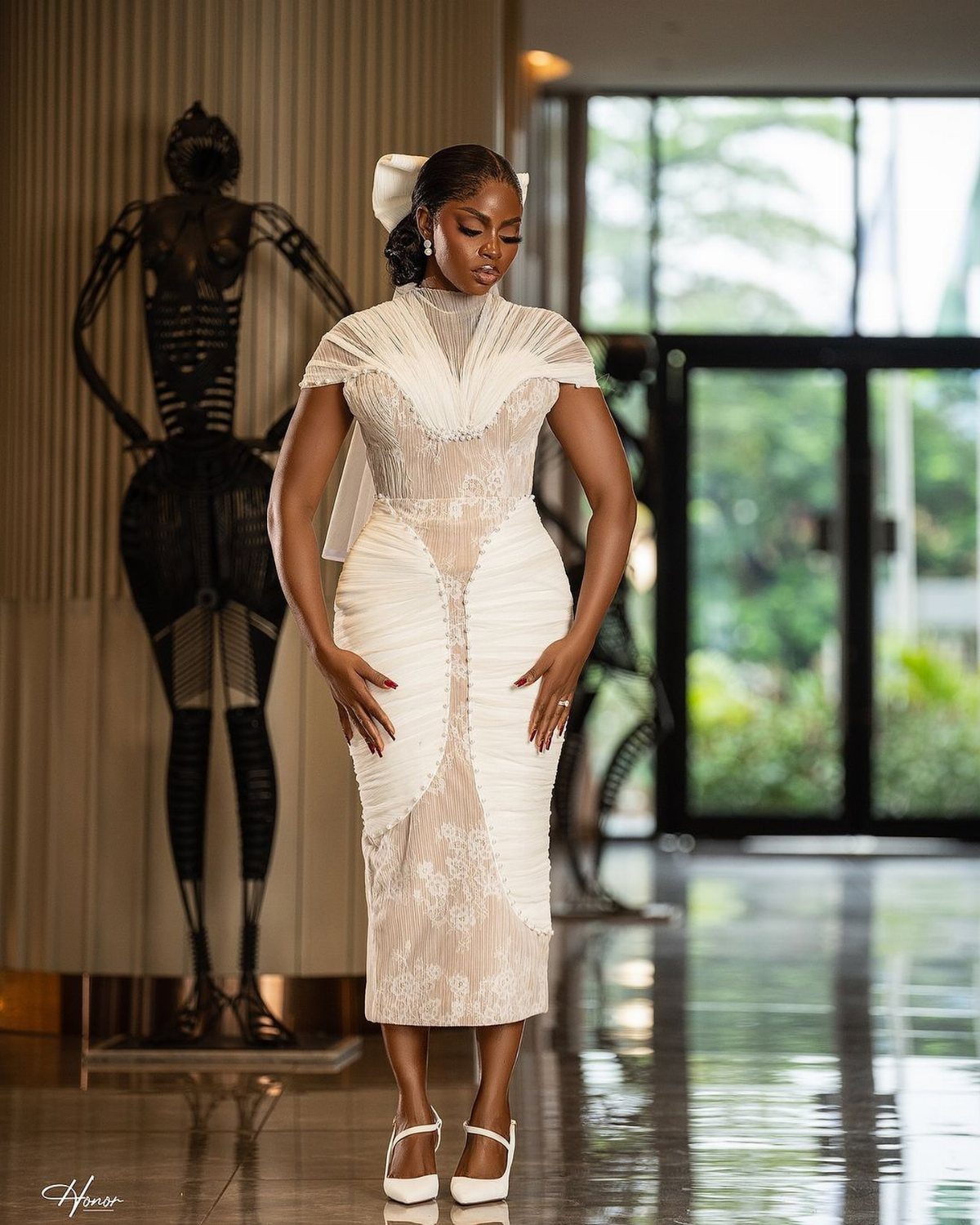 9 Court Wedding Outfit Ideas, From Jumpsuits to Mini Dresses 5 Woman in a white lace wedding dress with a high neck and white bow.