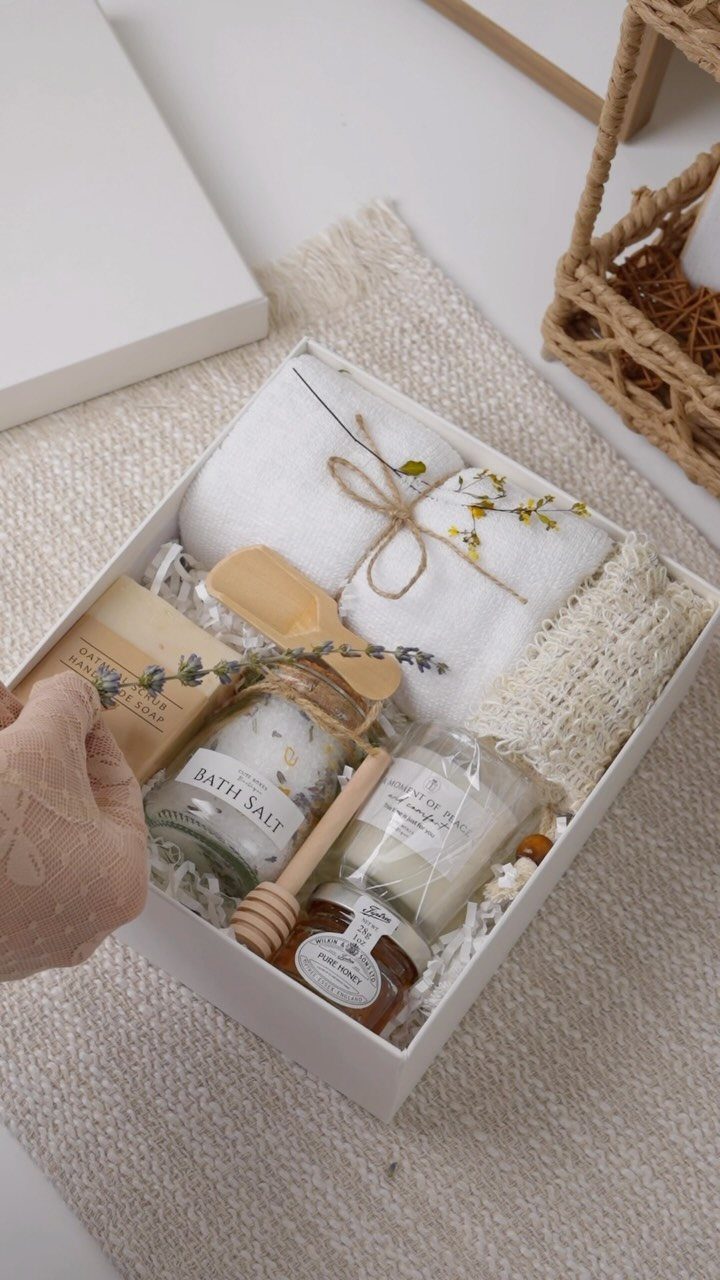 Spa gift box with white towel, bath salts, candle, honey, and handmade soap.