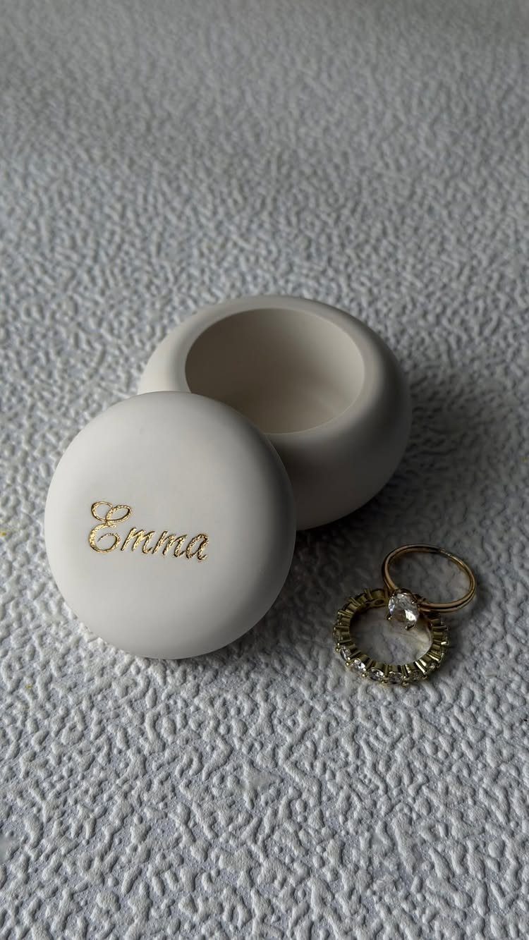 White ceramic jewelry box with gold name Emma and two gold wedding rings