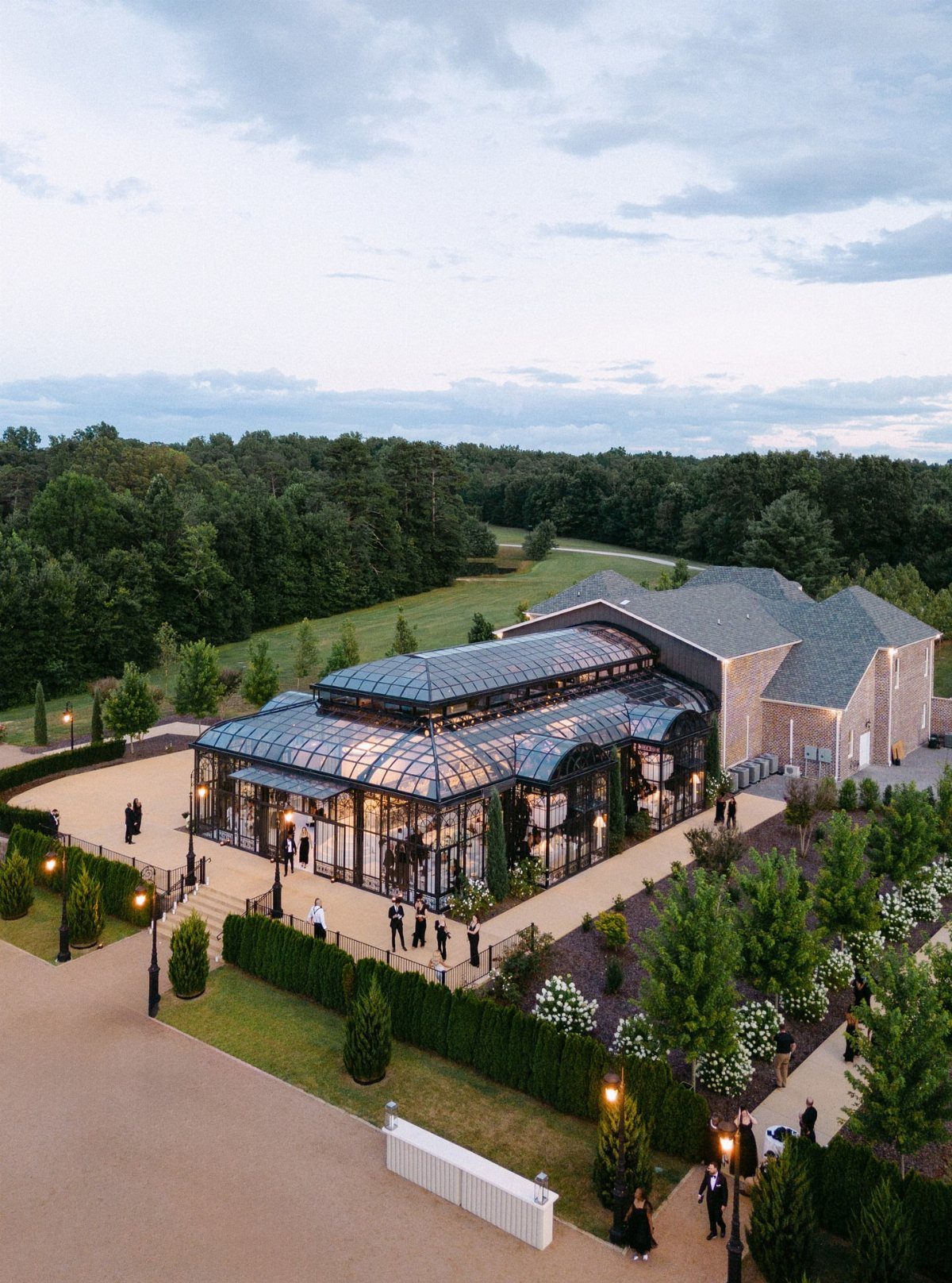 Dream Wedding Venue Ideas: 11 Places to Say I Do 7 Glass conservatory and event venue surrounded by lush gardens and dense green forests.