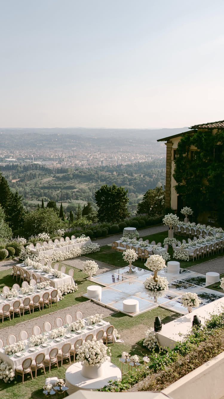 Dream Wedding Venue Ideas: 11 Places to Say I Do 6 Outdoor wedding reception with white tables and flowers overlooking a scenic city valley.