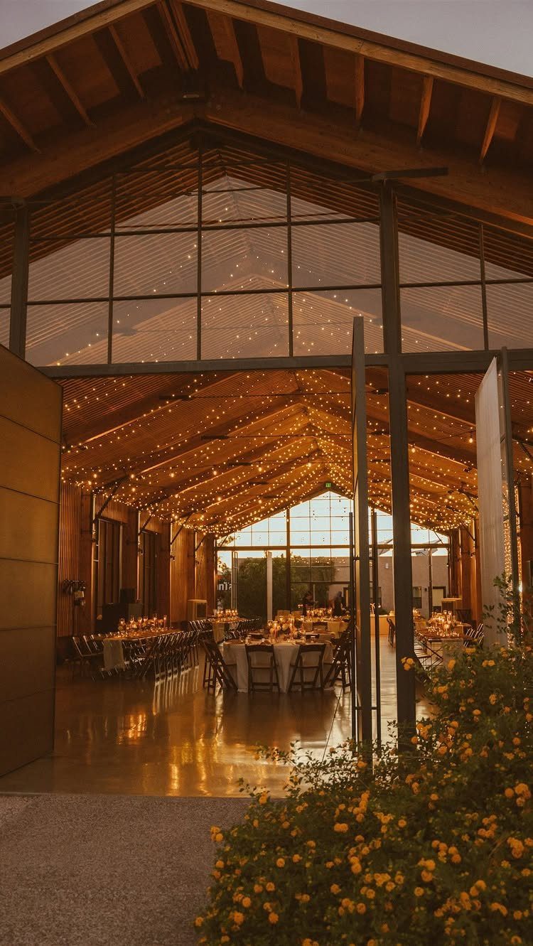 Dream Wedding Venue Ideas: 11 Places to Say I Do 11 Modern rustic event venue with wooden beams, string lights, and set dining tables.