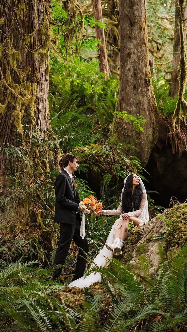 Fantasy Wedding Venue Ideas: 11 Storybook Settings 2 Bride and groom posing among giant mossy trees and ferns in a lush forest.