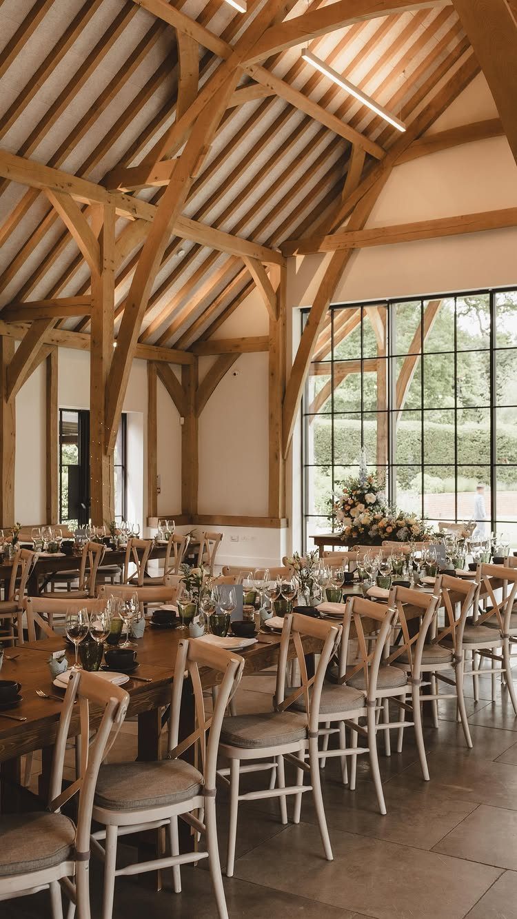 Fantasy Wedding Venue Ideas: 11 Storybook Settings 3 Modern barn interior with exposed wooden beams and elegant banquet table settings.