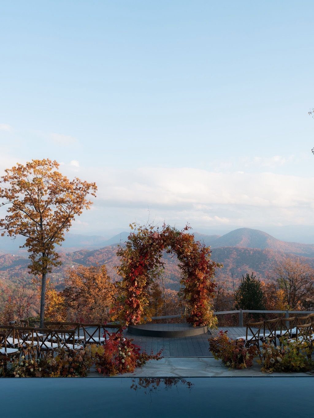 Fantasy Wedding Venue Ideas: 11 Storybook Settings 6 Autumn floral wedding arch overlooking a mountain landscape with colorful fall foliage.