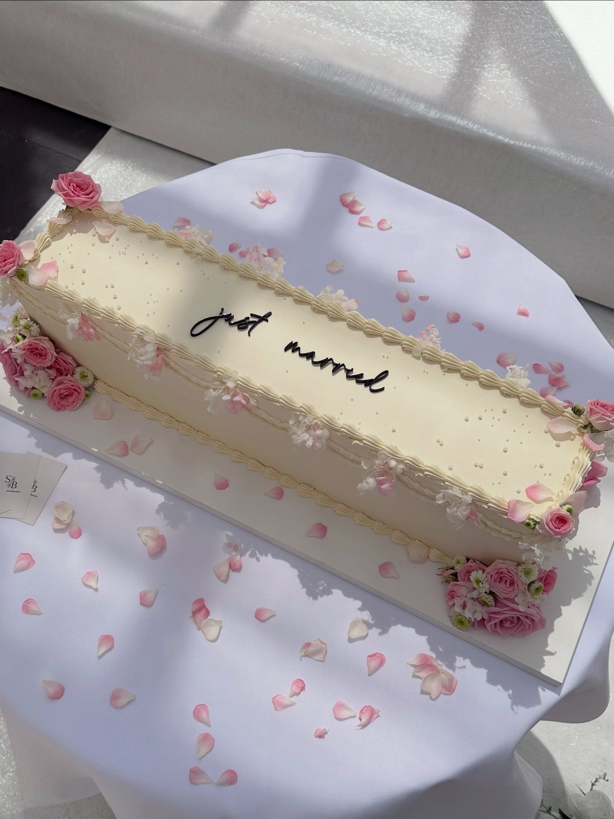 Flat Wedding Cakes: 6 Ideas for Simple, Low Tiers 4 Rectangular white sheet cake with pink roses and just married text on white table