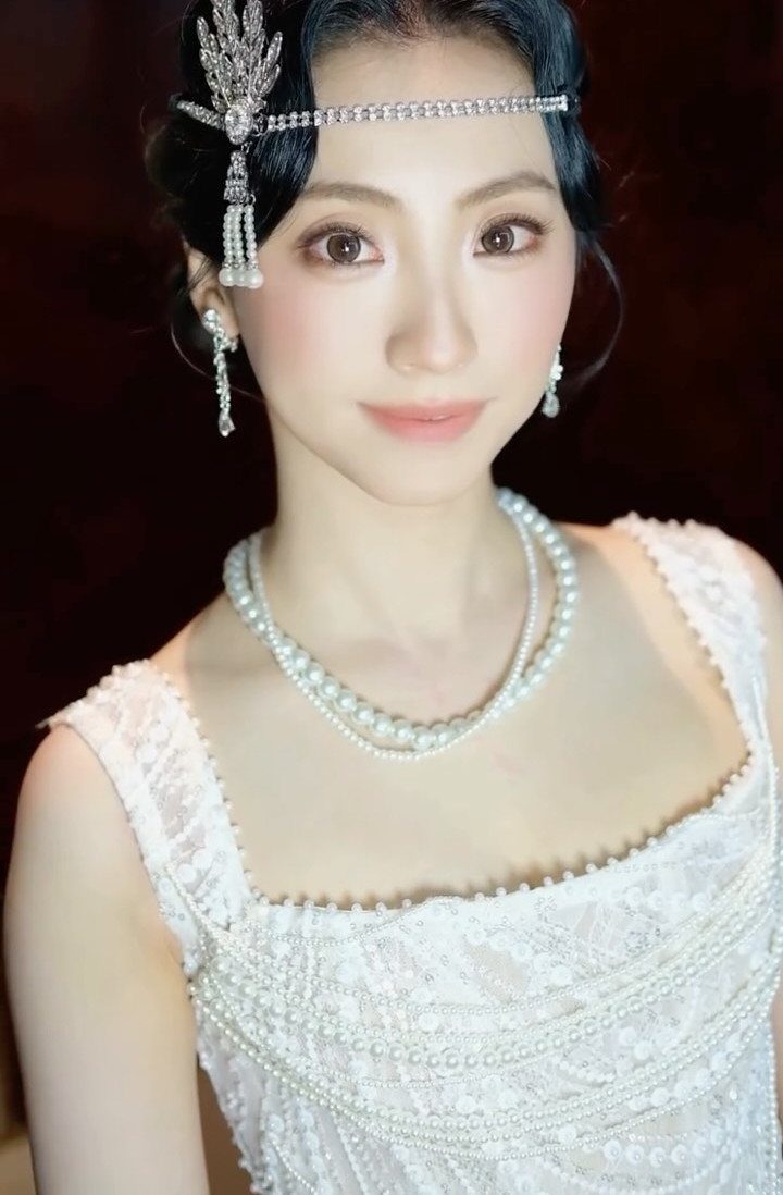 Woman in a beaded vintage wedding dress with a jeweled forehead headpiece.