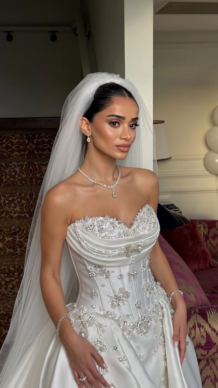 Woman in a modern glam wedding dress with silver embellishments and a white veil.