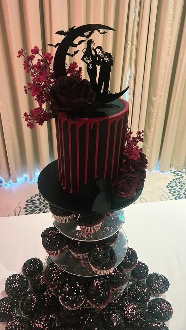 8 Gothic Romance Wedding Ideas for a Dark, Moody Day 6 Black gothic wedding cake with red drips, dark roses, and chocolate cupcakes.