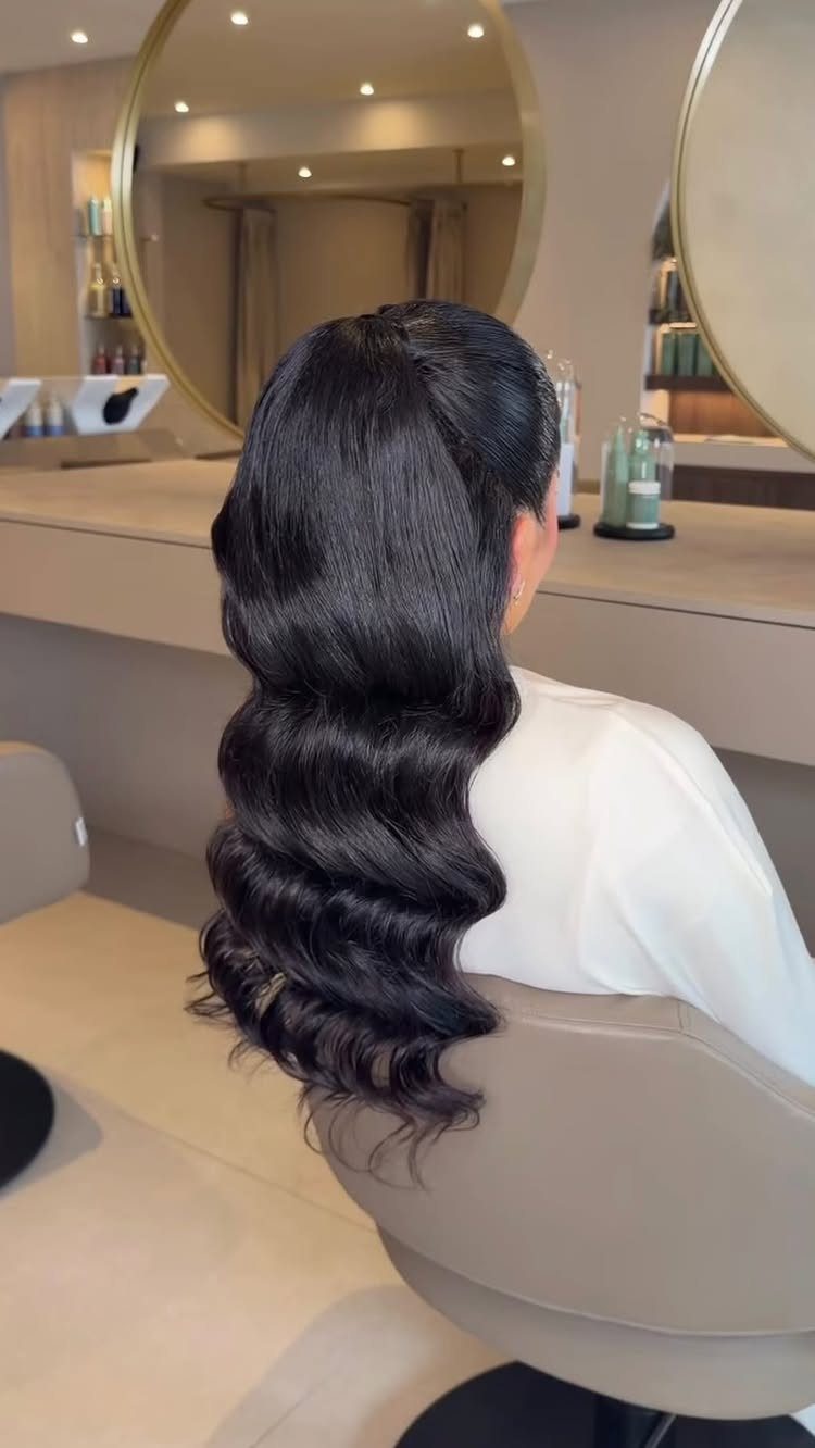 14 Ideas for Hair for a Wedding Guest, From Buns to Waves 6 Long dark hair styled in glamorous, structured Hollywood waves in a salon setting.