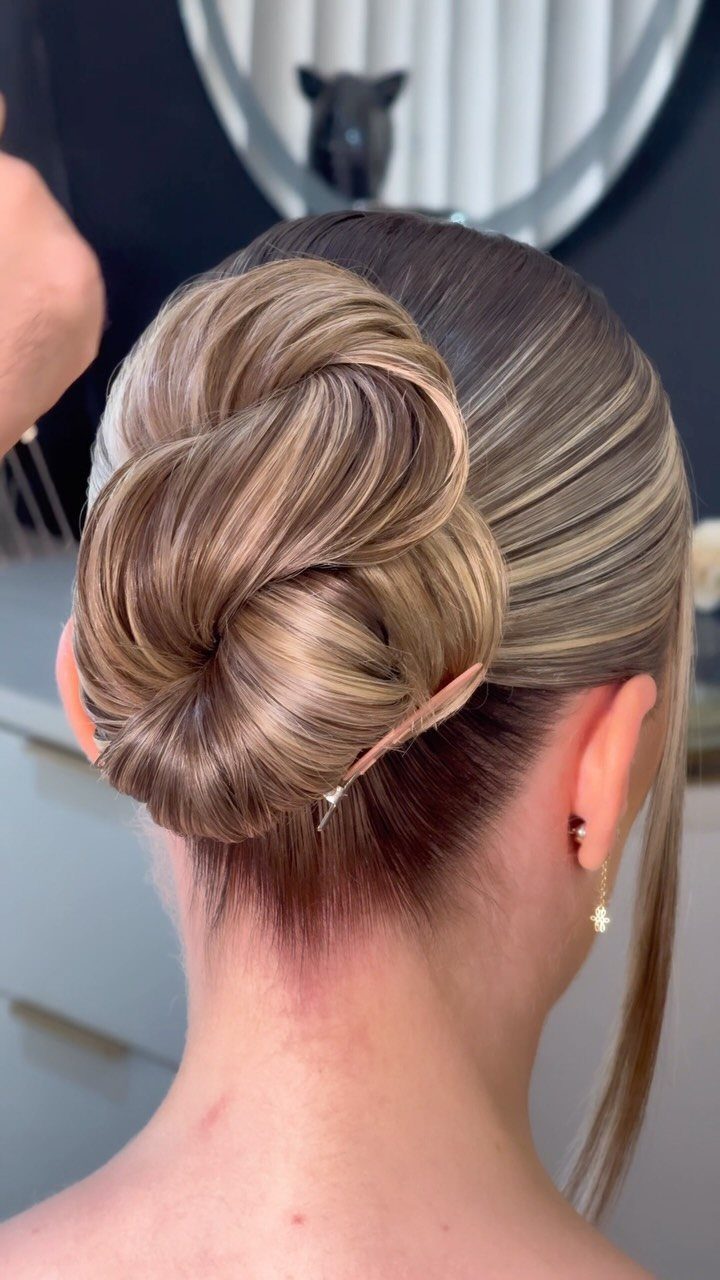14 Ideas for Hair for a Wedding Guest, From Buns to Waves 2 Sculpted blonde and brown hair styled into a smooth, polished twisted bun updo.
