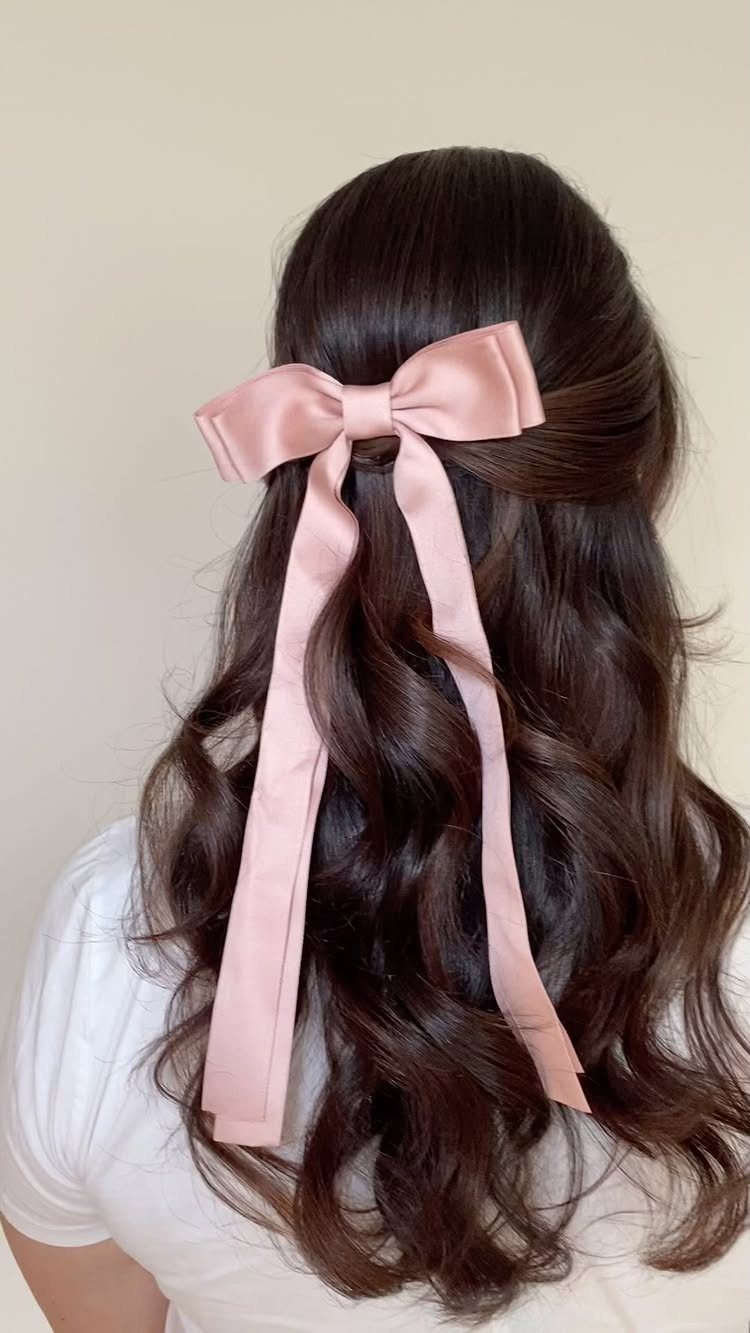 11 Half Up and Down Wedding Hair Ideas for Brides 10 Long wavy brown hair styled half-up with a large pink satin bow.