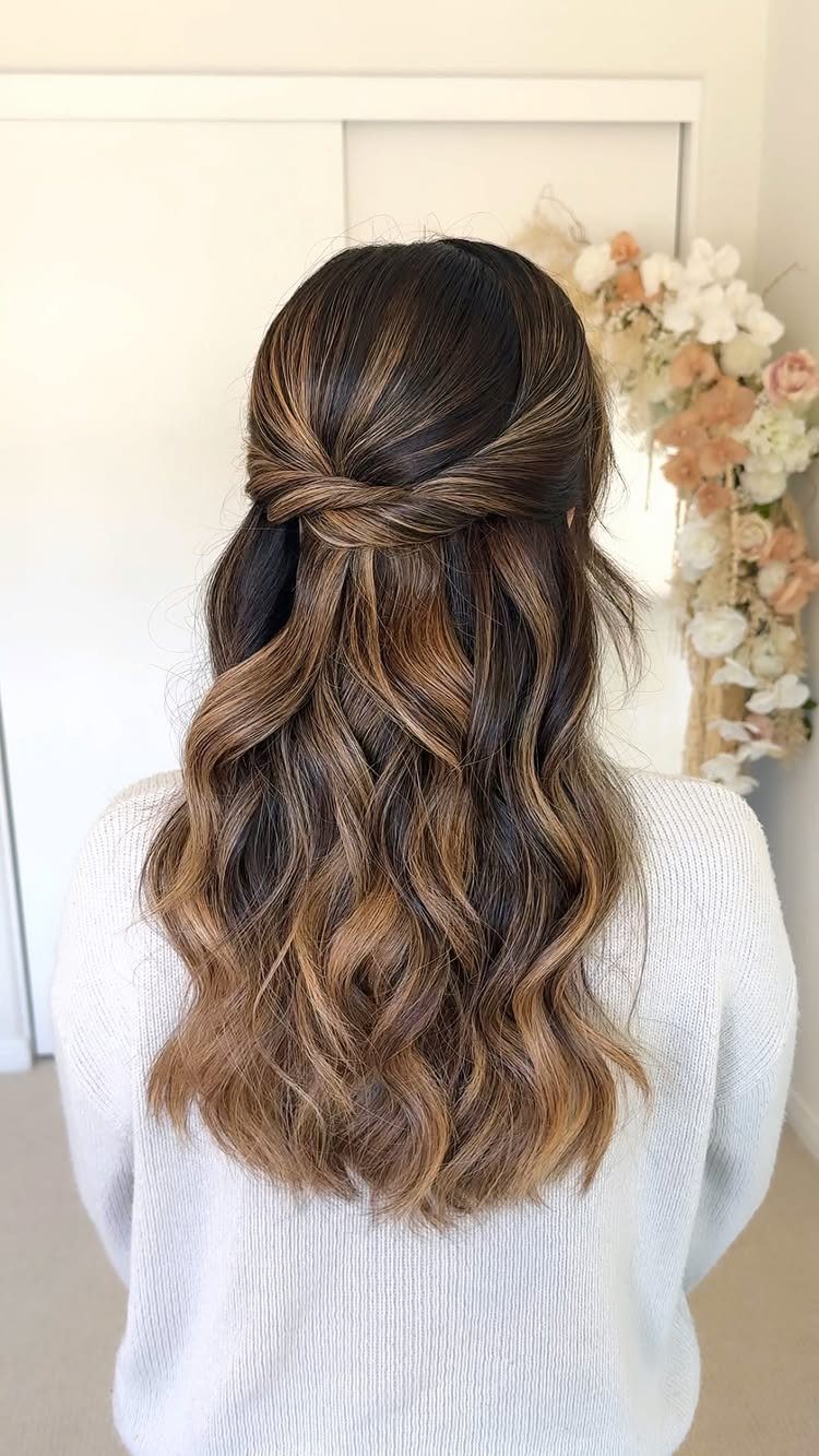 11 Half Up and Down Wedding Hair Ideas for Brides 4 Woman with long wavy brown hair styled in a twisted half up hairstyle