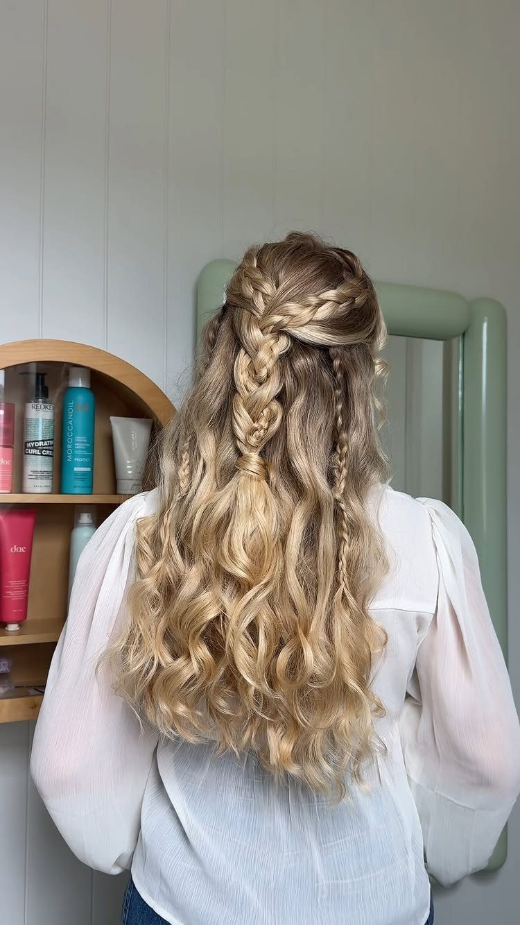 Blonde curly hair styled in a braided half up half down wedding hairstyle.