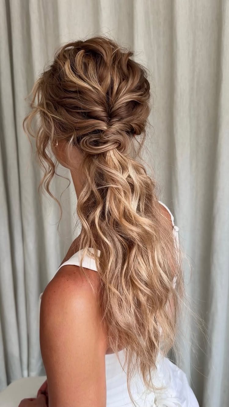Blonde wavy hair styled in a low pony half updo for a wedding.