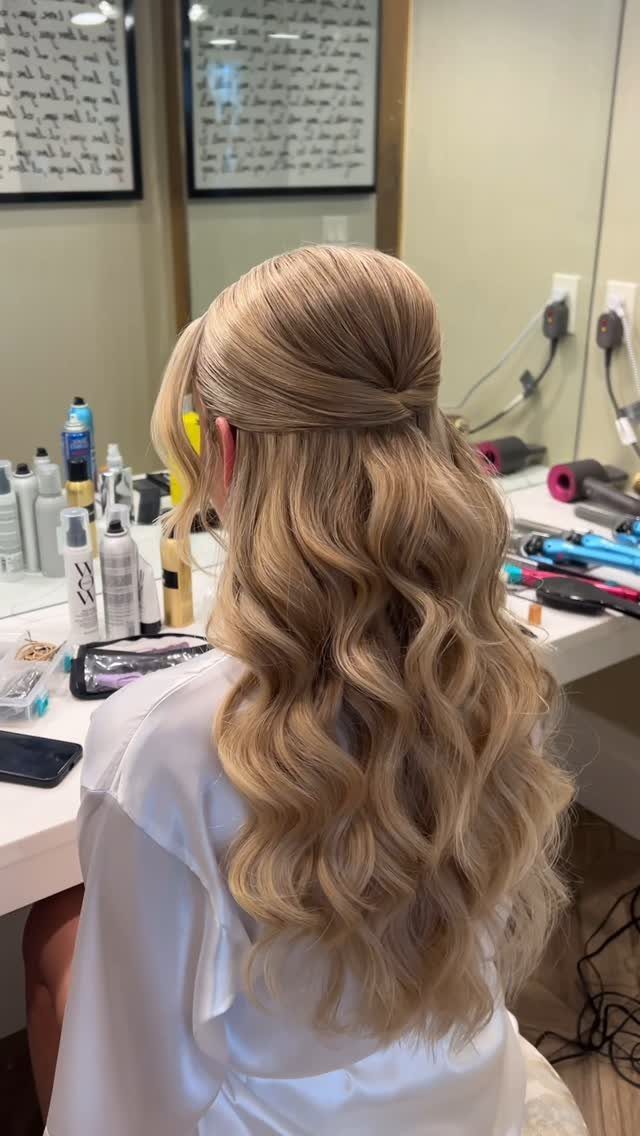 Long blonde hair in a soft, tousled half-updo with voluminous curls and waves.