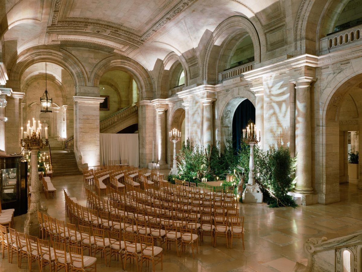 Grand marble hall with vaulted ceilings and rows of chairs for a wedding ceremony.