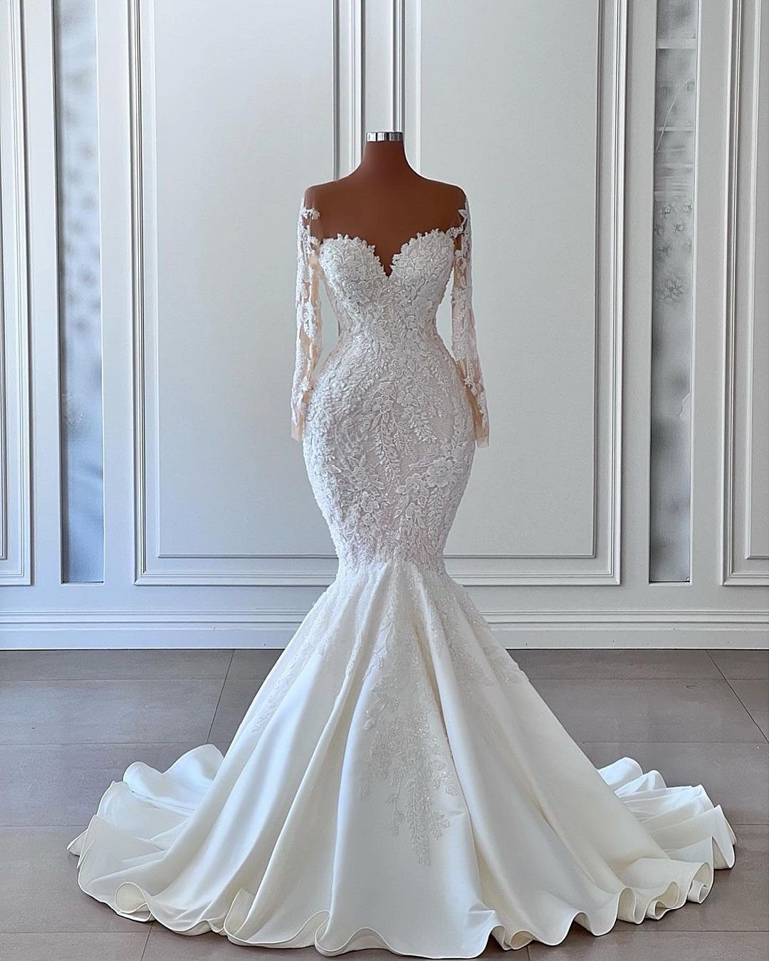 Ivory mermaid wedding dress with lace bodice and flared skirt on a mannequin