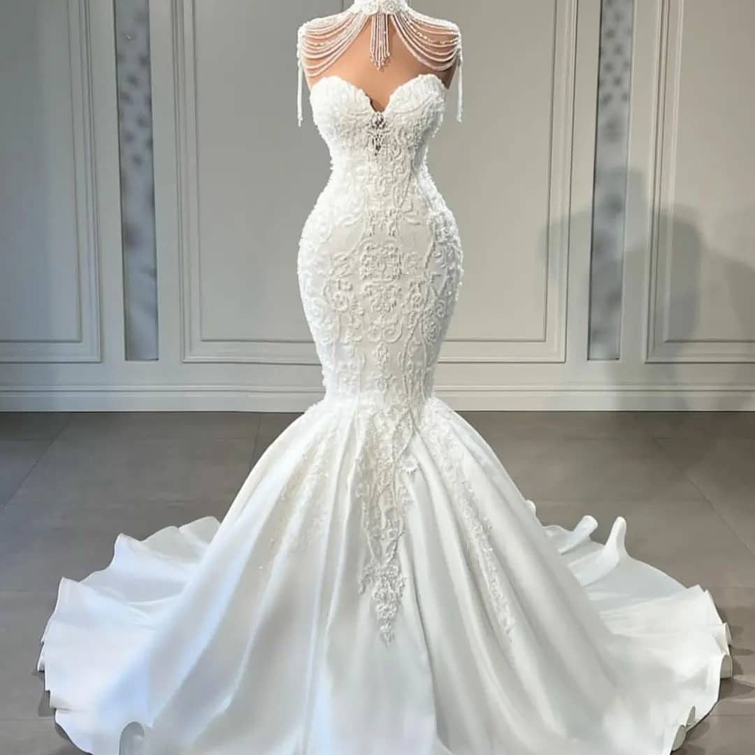 Ivory mermaid wedding dress with lace embroidery and a beaded shoulder cape.