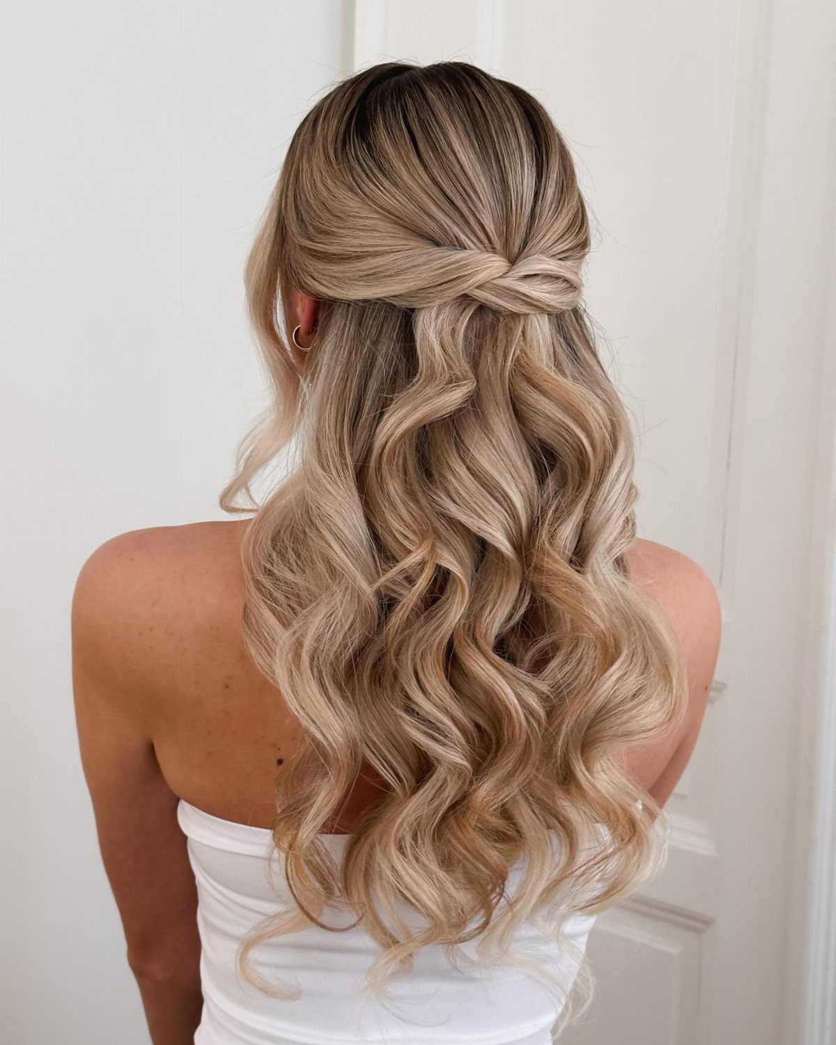 15 Long Hair Wedding Styles for Braids, Buns and Waves 6 Long blonde wavy hair styled in a half-up twist with cascading curls.