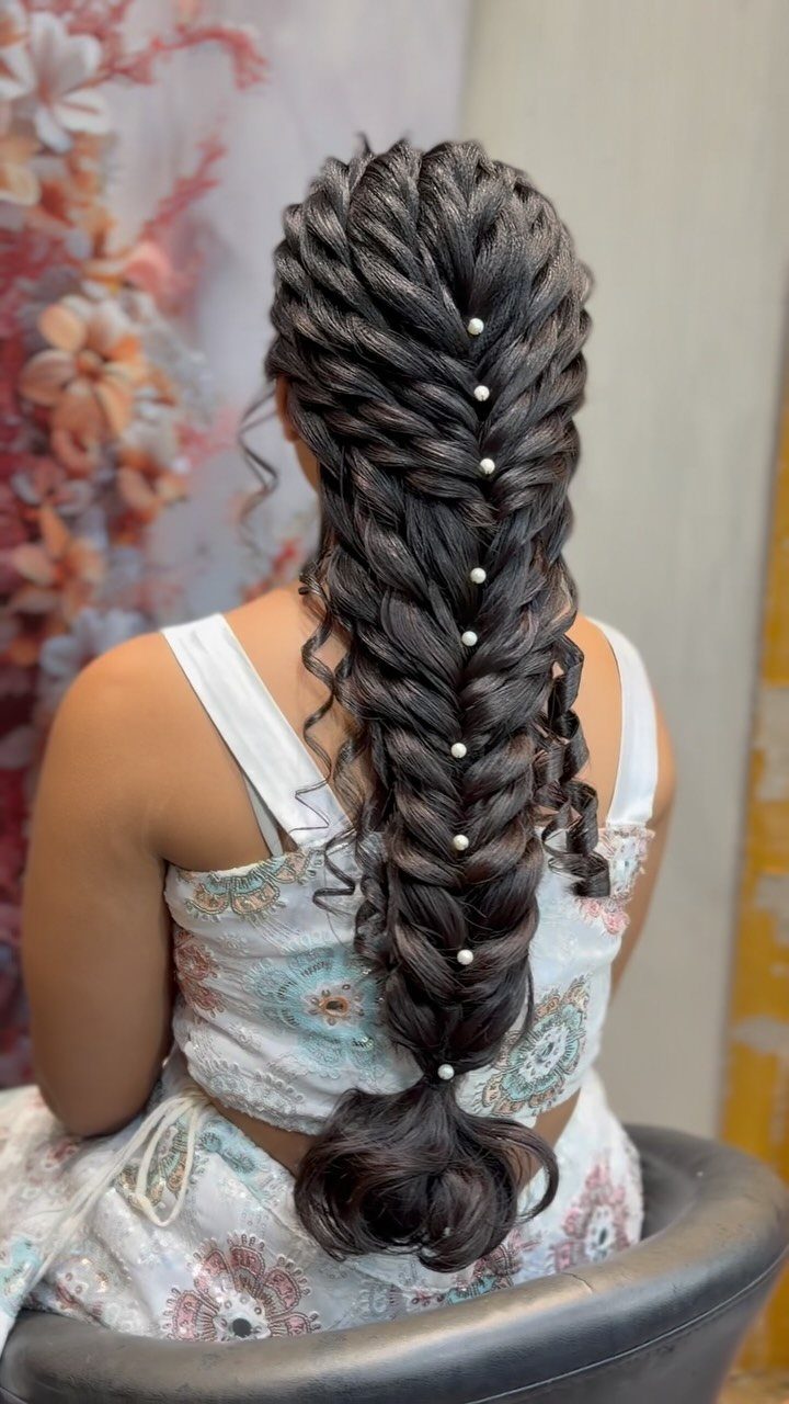 15 Long Hair Wedding Styles for Braids, Buns and Waves 7 Long dark hair in a voluminous bridal braid with pearls and cascading curls.