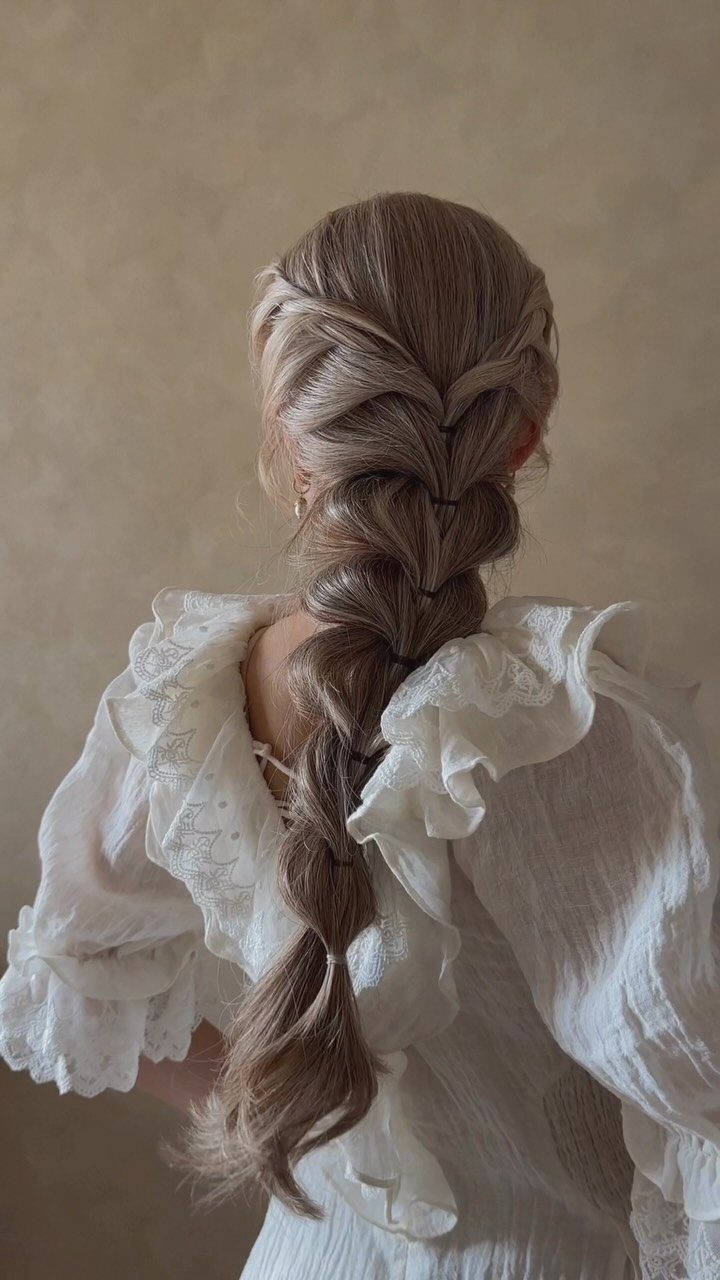 15 Long Hair Wedding Styles for Braids, Buns and Waves 9 Long light brown hair styled in a thick, loose braid on a woman.