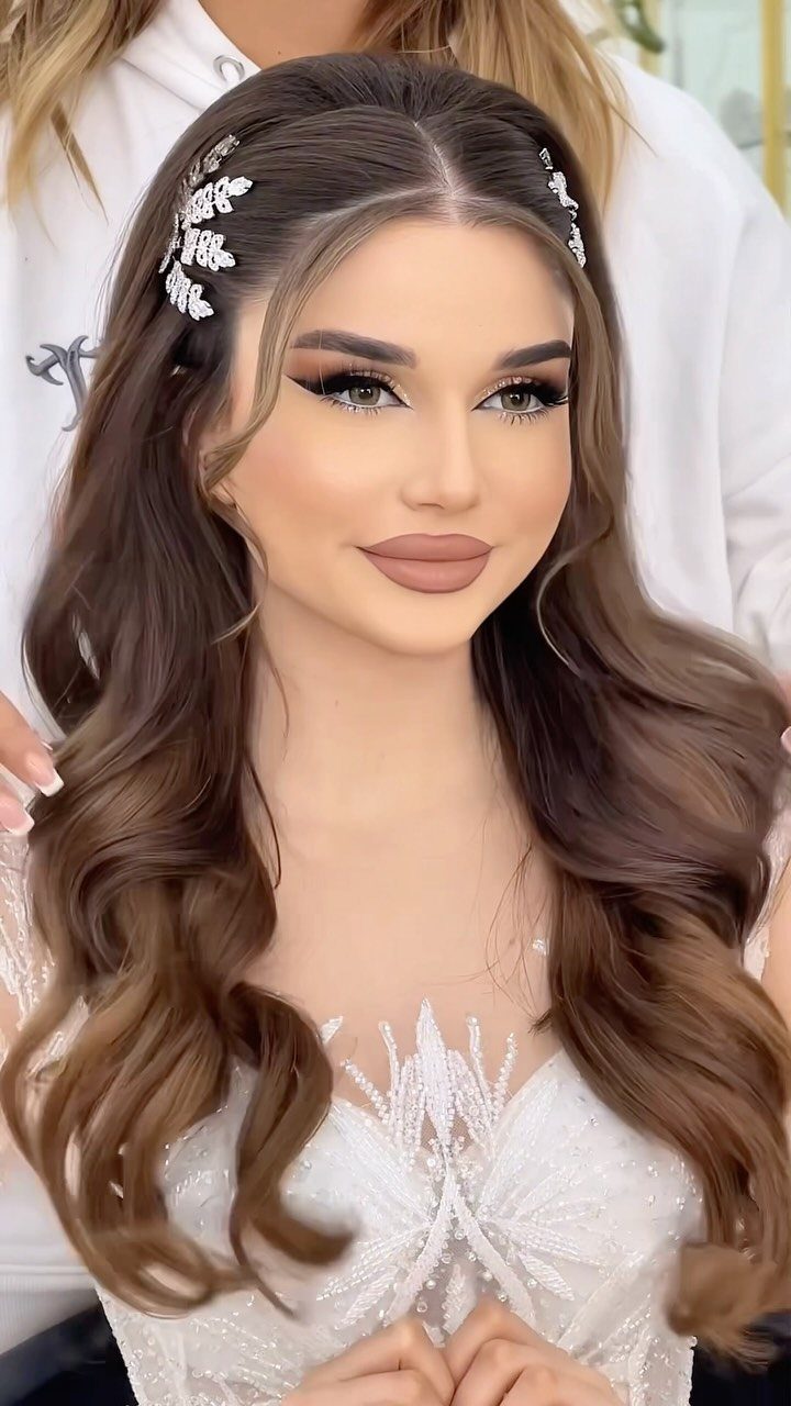 15 Long Hair Wedding Styles for Braids, Buns and Waves 12 Woman with long wavy brown hair and silver leaf accessory in bridal gown