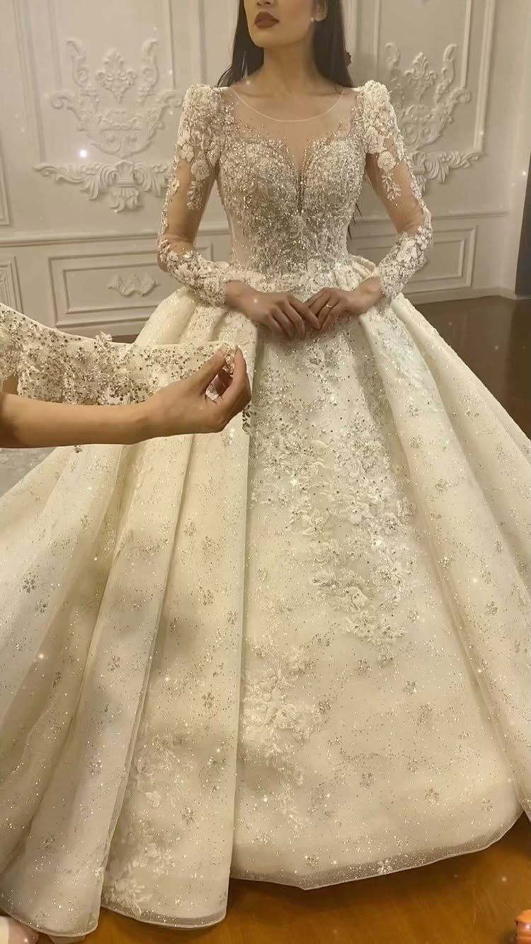 Ivory wedding dress with long lace sleeves and a full embroidered skirt.