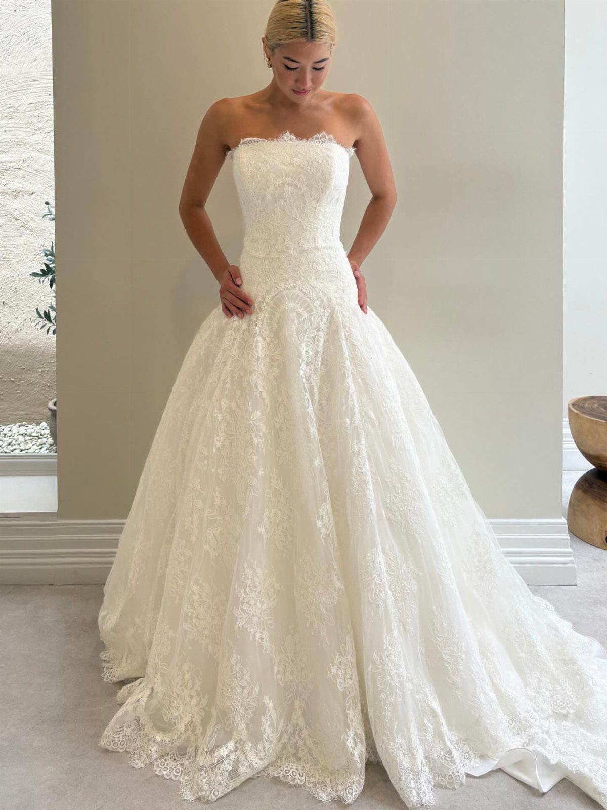 Woman wearing a strapless white lace wedding dress with a full voluminous skirt
