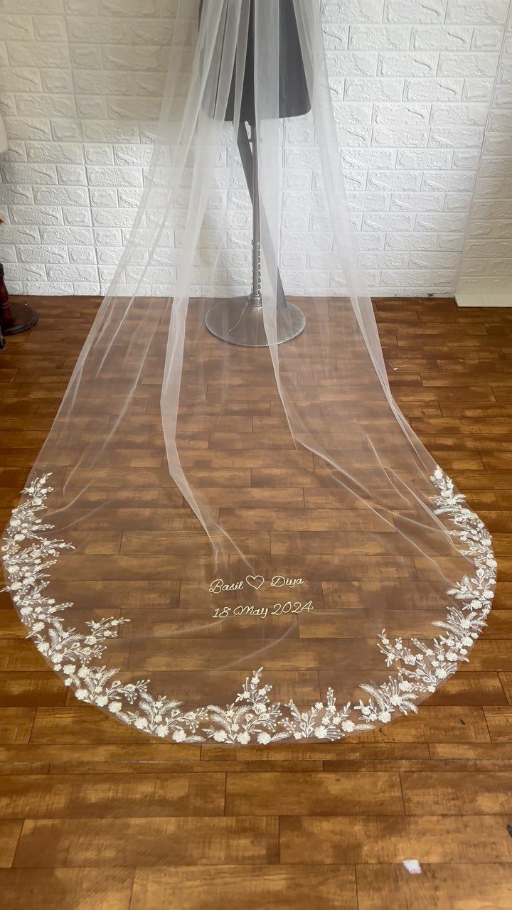 White bridal mantilla veil with lace embroidery draped on a mannequin stand