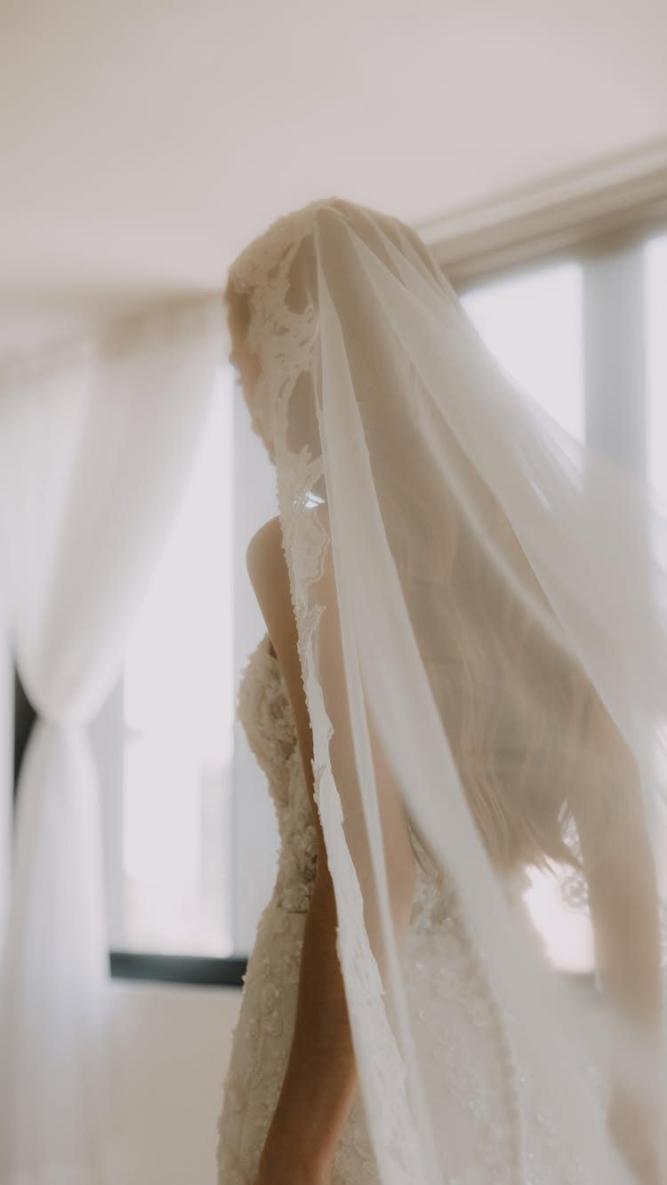 Bride wearing a white lace mantilla veil and matching wedding dress.