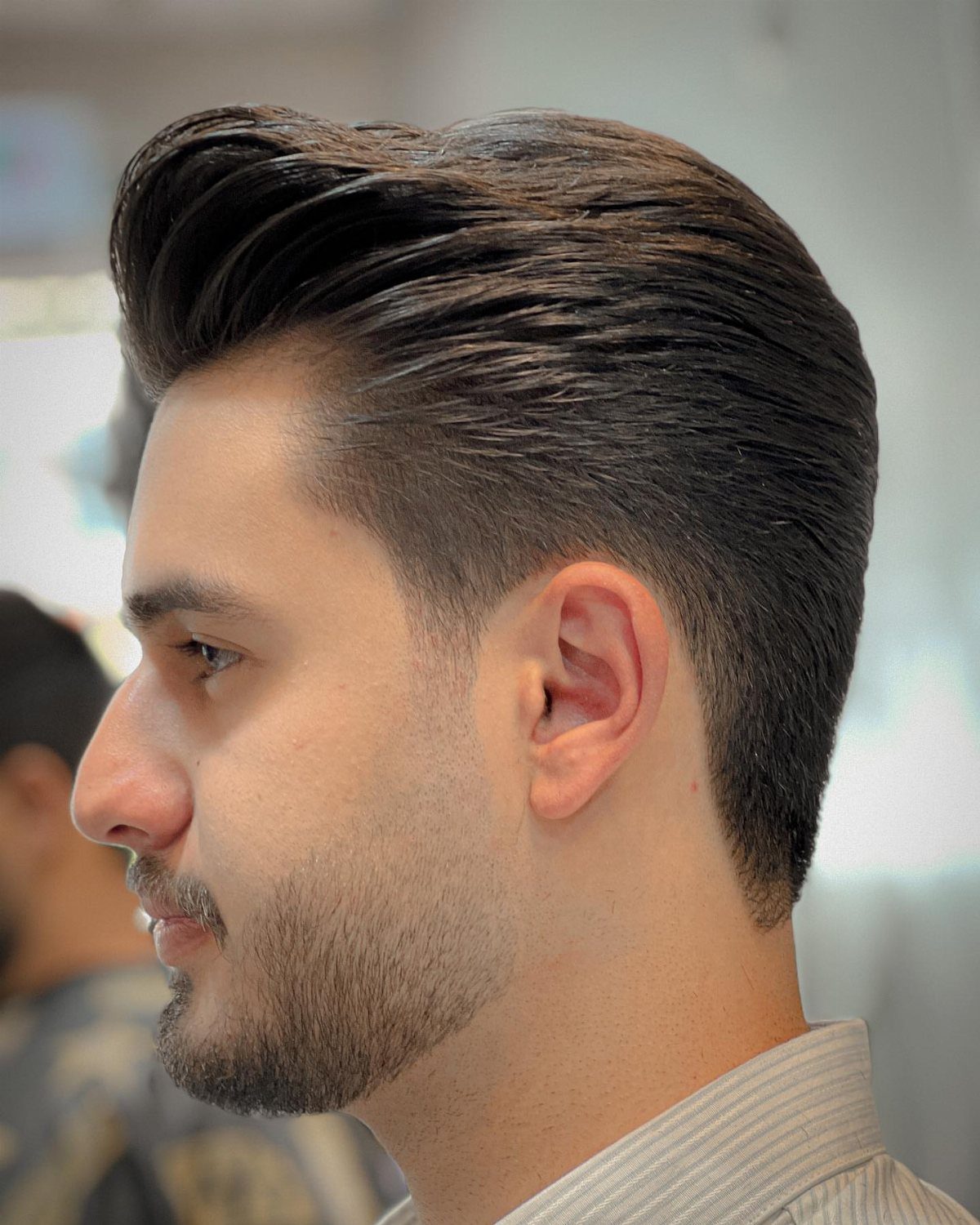 Man with a high volume pompadour hairstyle and a faded side profile.