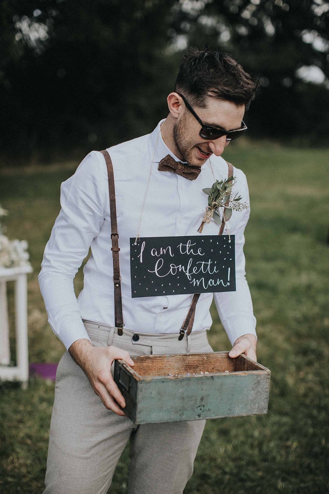 No Wedding Party? 6 Ideas for Celebrating Without One 5 Man in wedding attire holding a confetti crate with a chalkboard sign.