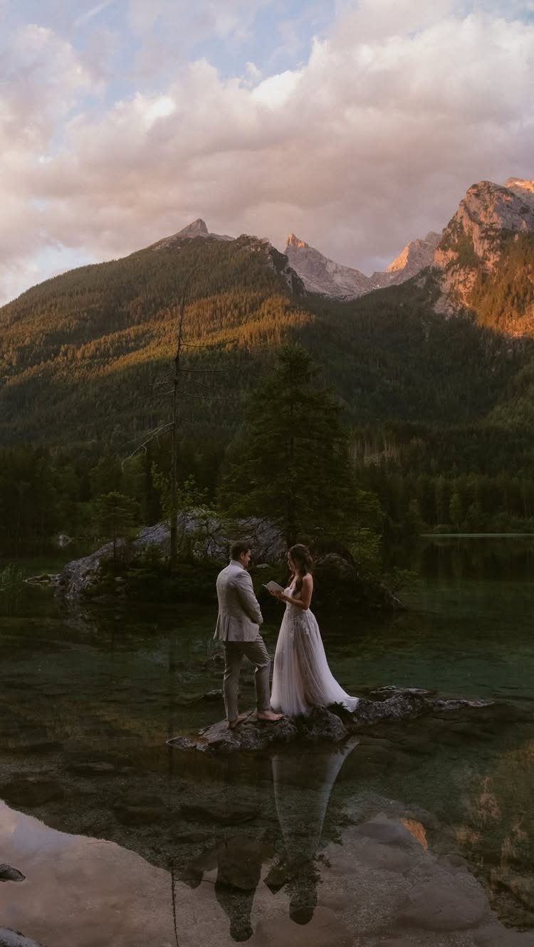 No Wedding Party? 6 Ideas for Celebrating Without One 2 Couple in wedding attire standing on rocks by a lake with mountains behind them
