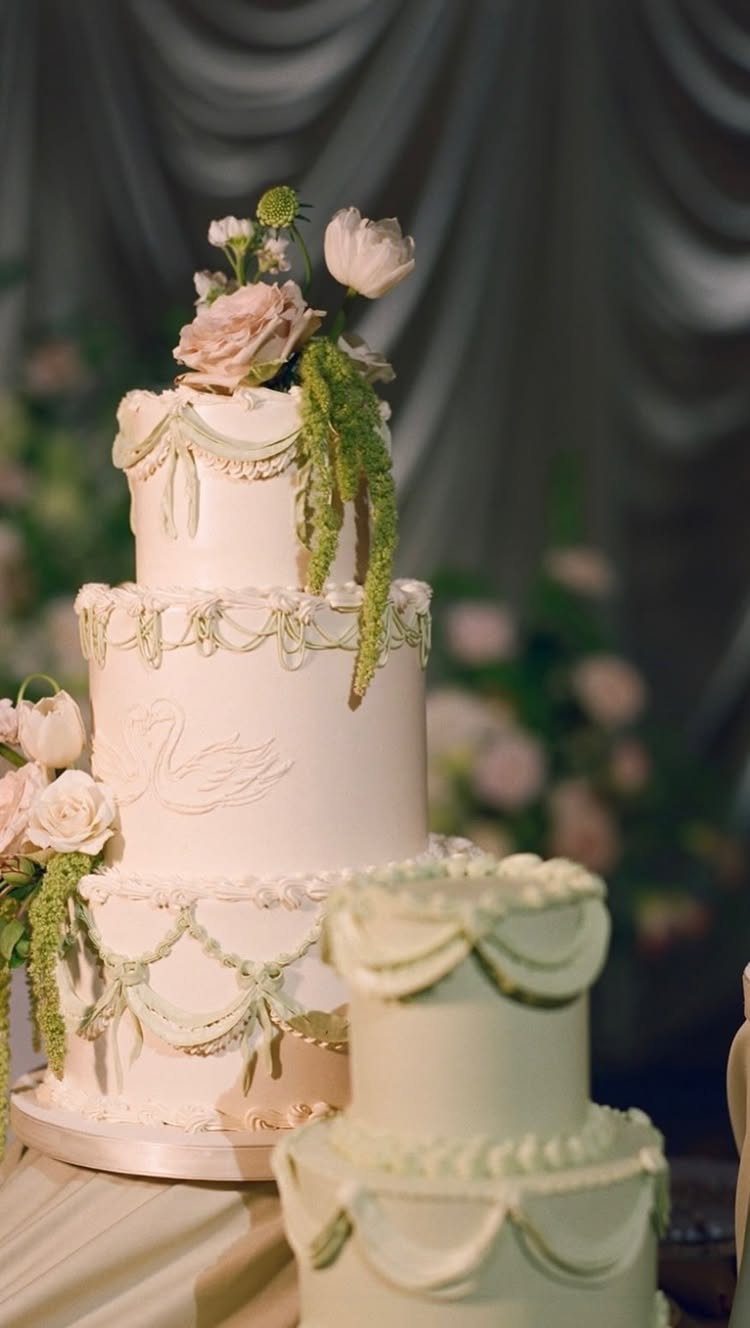 White multi-tiered Lambeth wedding cake with intricate buttercream piping and pale pink roses.