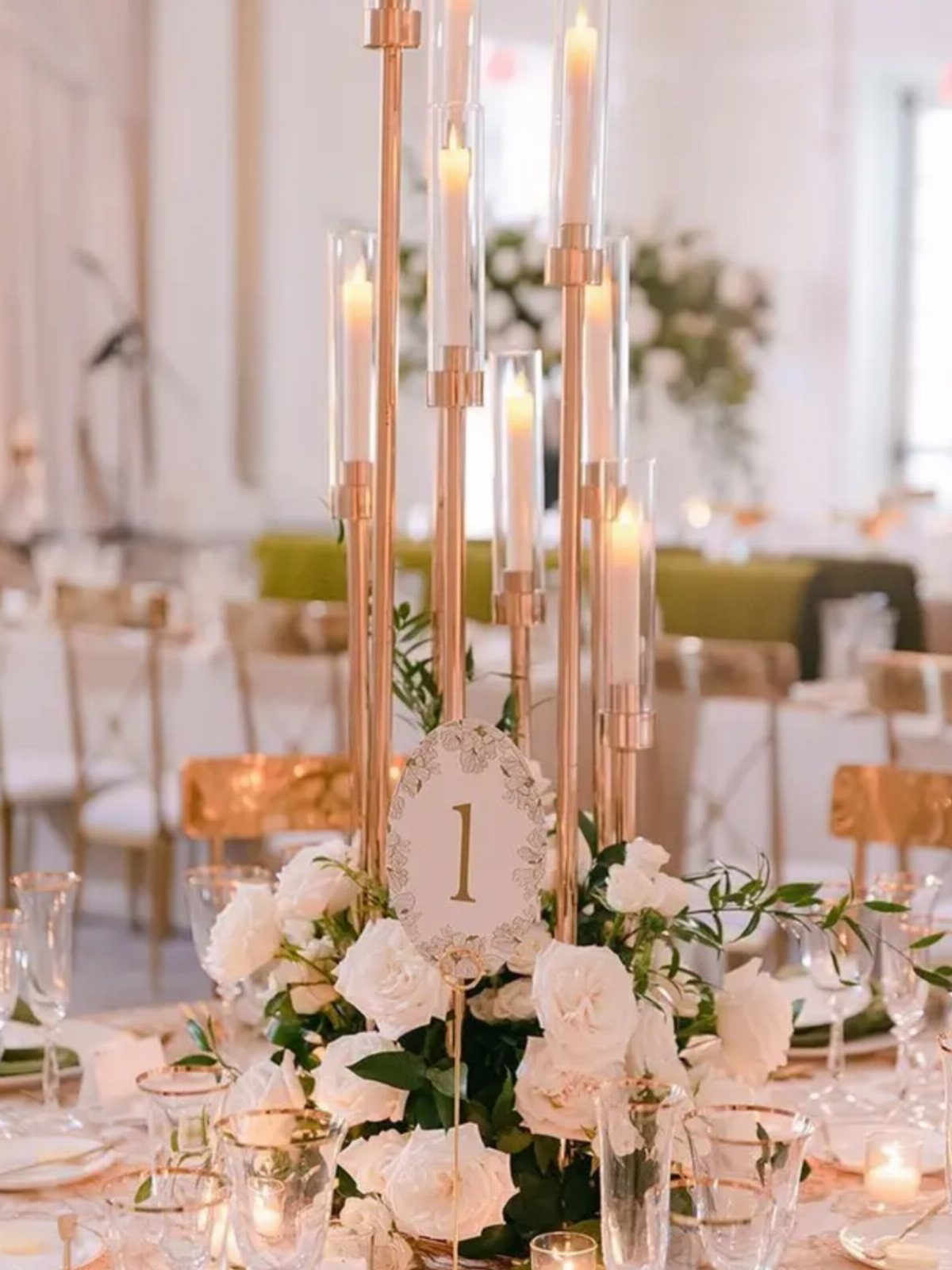 Gold candelabra with white candles and roses as a wedding table centerpiece.