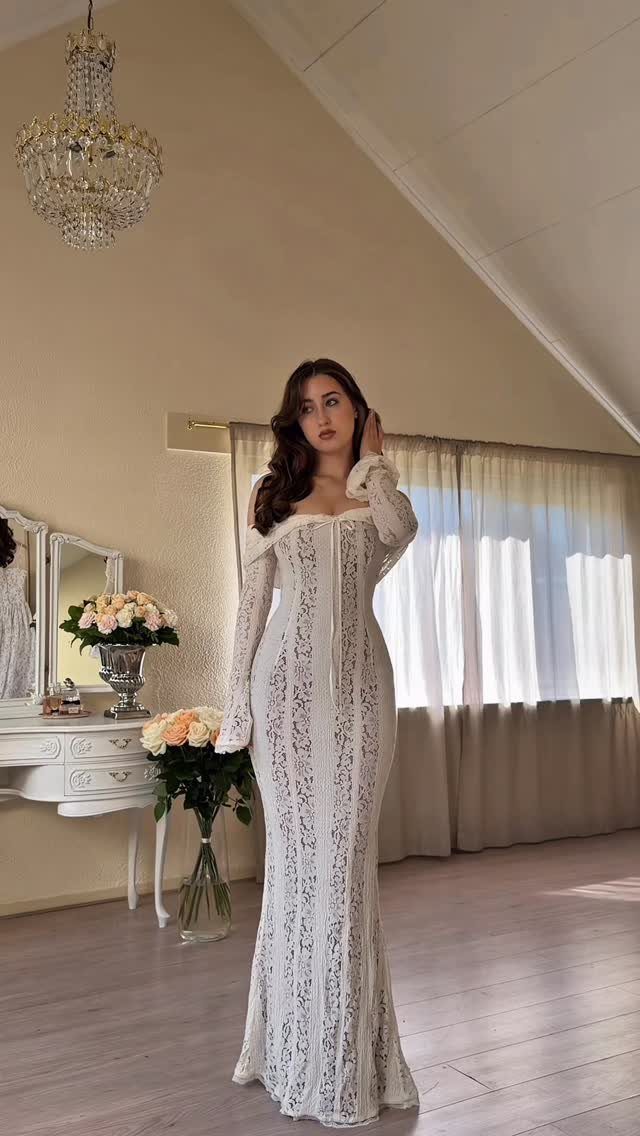 12 Pre Wedding Photoshoot Outfit Ideas for Couples 4 Woman in a long white lace dress posing in a bright, elegant room.