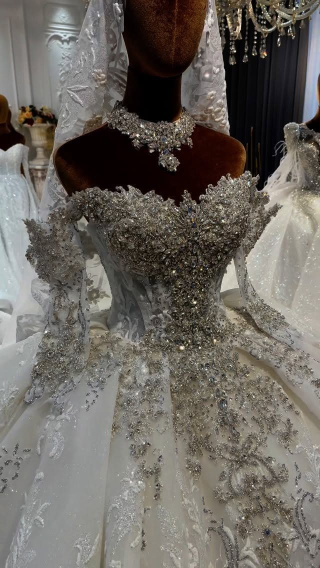 White wedding dress with heavy silver embellishments and lace on a mannequin.